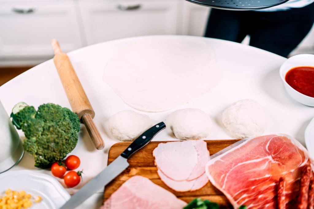 Cooking in the new kitchen - details of table full of vegetables and cooking tools